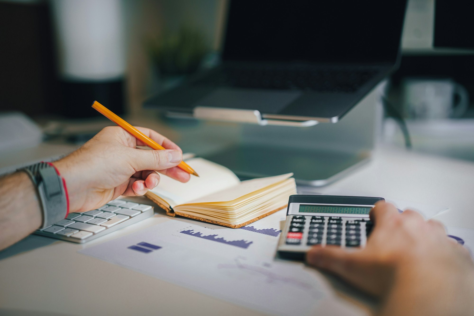 A student working through costs with a calculator and notebook