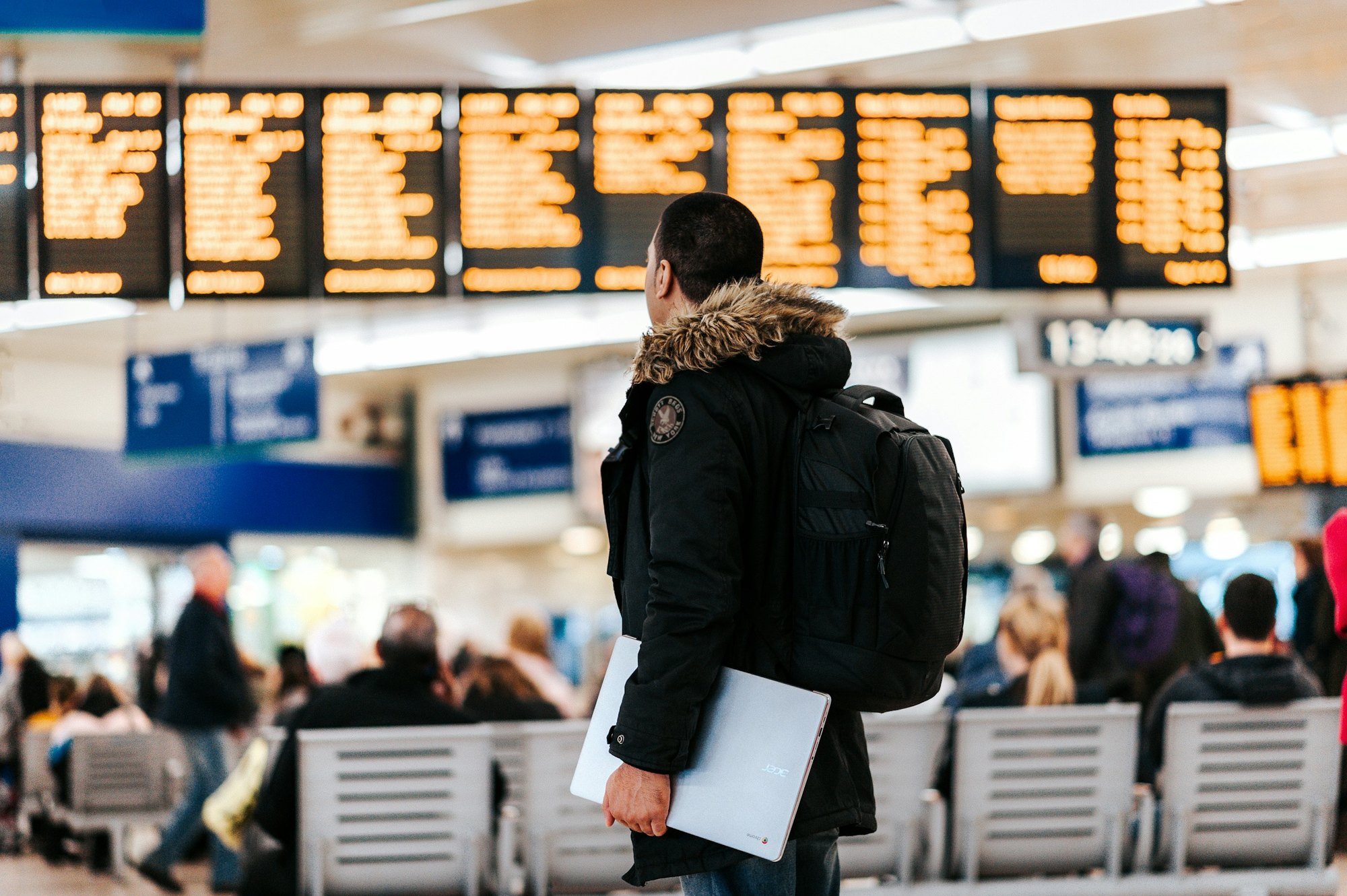 A traveler reading the departures board at an airport